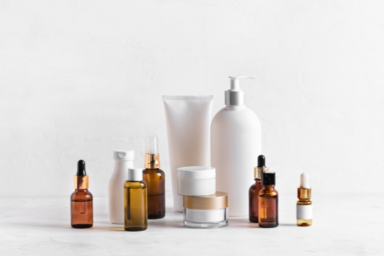 A range of skincare bottles, tubes and amber dropper bottles